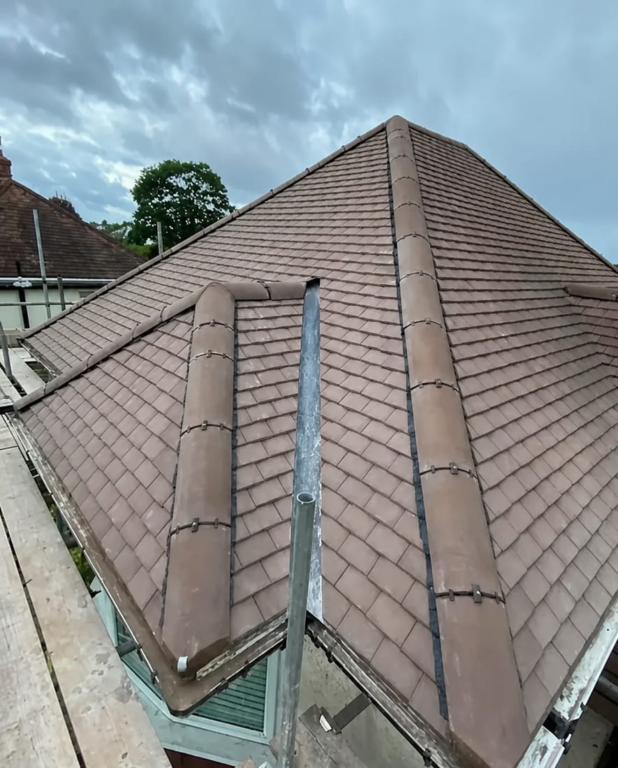 Close view of a newly tiled hipped roof with bedded hip and ridge tiles