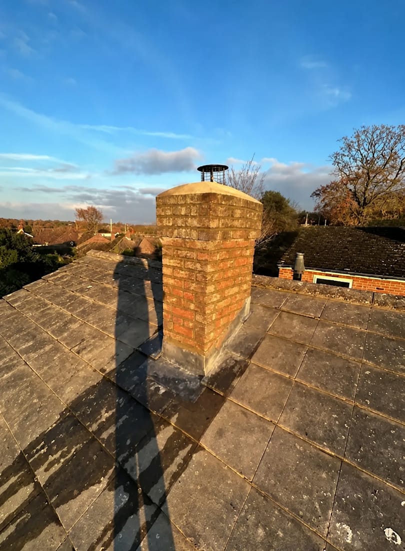 Repointed brick chimney stack with new lead flashing and a fitted cowl